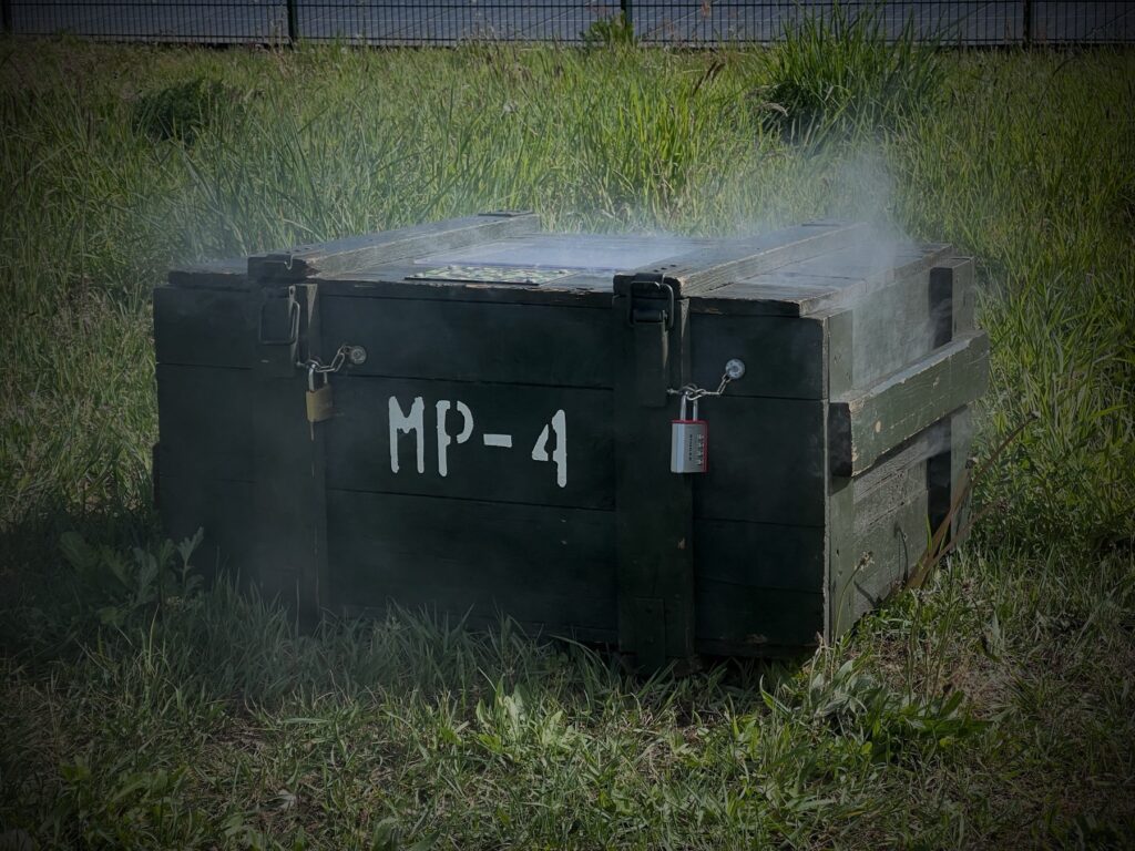 Legergroene bomkist MP-4 met hangsloten en rook bij Red Alert
